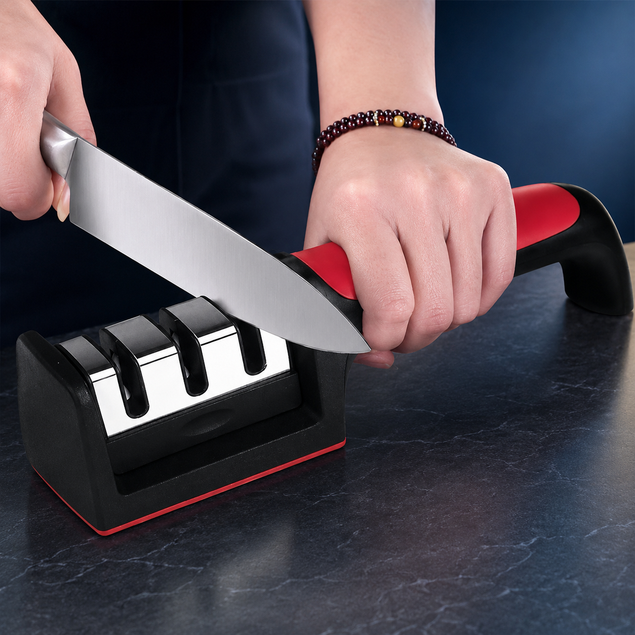 Multi-stage handheld knife sharpener on a midnight blue studio backdrop